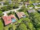 An aerial view of the backyard pool with screened-in enclosure and red clay tile roof at 7324 Links Ct, Sarasota, FL 34243