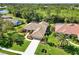Beautiful home with a tile roof surrounded by mature trees and lush landscaping at 7324 Links Ct, Sarasota, FL 34243