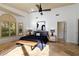 Bright primary bedroom with a ceiling fan, large window, and elegant tile floors at 7324 Links Ct, Sarasota, FL 34243