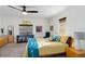 Bright bedroom featuring a ceiling fan, large window, and a comfortable bed with yellow bedding at 7324 Links Ct, Sarasota, FL 34243