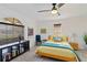 Bright bedroom featuring a ceiling fan, large window, and a comfortable bed with yellow bedding at 7324 Links Ct, Sarasota, FL 34243