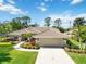 Inviting home with a tile roof, manicured lawn, mature landscaping, and a spacious driveway leading to the garage at 7324 Links Ct, Sarasota, FL 34243