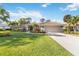 Charming home featuring a lush green lawn and beautiful tropical landscaping at 7324 Links Ct, Sarasota, FL 34243