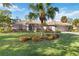 Charming home featuring lush landscaping, tile roof, and a well-manicured lawn with a large central palm tree at 7324 Links Ct, Sarasota, FL 34243