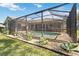 A screened-in pool with paved patio surrounded by lovely landscaping and lush green grass at 7324 Links Ct, Sarasota, FL 34243