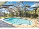 Relaxing pool with a screened-in lanai, paved patio and tropical landscaping at 7324 Links Ct, Sarasota, FL 34243