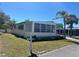 Charming single-story home featuring large windows, a well-maintained lawn, and shaded by a mature palm tree at 733 Roma Rd, Venice, FL 34285