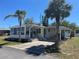 Inviting single-story home with a carport, neatly landscaped yard, and vibrant green trim on the exterior at 733 Roma Rd, Venice, FL 34285