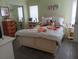 Bright bedroom with floral bedding, tile floors, and ample natural light at 805 S Waterway, Venice, FL 34285