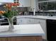 Kitchen featuring island with white countertops, modern appliances and white cabinets at 805 S Waterway, Venice, FL 34285