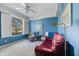 This cozy bedroom is painted in blue with a large window, letting in plenty of natural light and garden view at 915 Tartan Dr # 29, Venice, FL 34293
