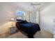 Cozy bedroom features a ceiling fan, window with blinds, and a bedside lamp at 915 Tartan Dr # 29, Venice, FL 34293