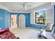 This cozy bedroom features blue walls, a large window with garden views and a white armoire at 915 Tartan Dr # 29, Venice, FL 34293