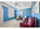 Bright blue bedroom with window, plush red sofa and accent furniture create a peaceful retreat at 915 Tartan Dr # 29, Venice, FL 34293