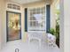 Inviting front porch featuring a cozy seating area, decorative statuary, and a stylish glass door at 915 Tartan Dr # 29, Venice, FL 34293