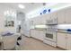 Well-lit kitchen with white cabinetry, modern appliances, and adjacent dining area, designed for both functionality and style at 915 Tartan Dr # 29, Venice, FL 34293