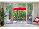 Inviting patio area with red umbrella and chairs offers a relaxing outdoor living space with beautiful natural views at 915 Tartan Dr # 29, Venice, FL 34293