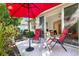 Cozy patio with chairs and red umbrella offers a perfect spot for outdoor relaxation and backyard views at 915 Tartan Dr # 29, Venice, FL 34293