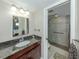 Bathroom with granite countertop vanity, mirror, and tiled walk-in shower at 950 Tarpon Center Dr # 506, Venice, FL 34285