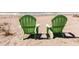 Two green Adirondack chairs facing the ocean on the sandy beach at 950 Tarpon Center Dr # 506, Venice, FL 34285