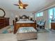 Bedroom with wood furnishings, ceiling fan, and access to a balcony at 950 Tarpon Center Dr # 506, Venice, FL 34285