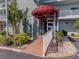 Entrance to the building with landscaped walkway, tropical landscaping, and covered entrance at 950 Tarpon Center Dr # 506, Venice, FL 34285