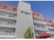 Exterior of condo building with balconies, red roof, and manicured greenery in a beautiful beachside community at 950 Tarpon Center Dr # 506, Venice, FL 34285