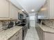 Long kitchen features granite countertops, stainless steel appliances, and mosaic backsplash at 950 Tarpon Center Dr # 506, Venice, FL 34285