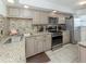 Kitchen with stainless steel appliances, granite counters, and mosaic backsplash at 950 Tarpon Center Dr # 506, Venice, FL 34285