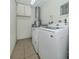 A laundry room with light colored tile and modern appliances at 950 Tarpon Center Dr # 506, Venice, FL 34285