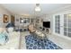 Spacious living room with tile flooring, a ceiling fan, and open layout towards the dining area at 950 Tarpon Center Dr # 506, Venice, FL 34285