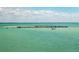 Picturesque aerial view of a pier stretching into the clear blue ocean, a stunning coastal feature at 9542 Spring Cir, Port Charlotte, FL 33981