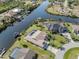 Waterfront home featuring a screened-in pool, boat dock, and lush landscaping on a sunny day at 9542 Spring Cir, Port Charlotte, FL 33981
