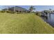 Lush green backyard with screened lanai and private boat dock, perfect for relaxing and enjoying the waterfront lifestyle at 9542 Spring Cir, Port Charlotte, FL 33981