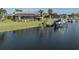 Waterfront home with a screened lanai, lush lawn, and boat dock with lift for easy water access at 9542 Spring Cir, Port Charlotte, FL 33981