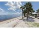 Scenic beach view showcasing white sand, palm trees, blue water, and a shaded picnic area for outdoor enjoyment at 9542 Spring Cir, Port Charlotte, FL 33981