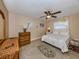 Comfortable bedroom features a ceiling fan, neutral paint, tile floors and a nice area rug to make the space cozy at 9542 Spring Cir, Port Charlotte, FL 33981