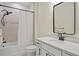 Clean bathroom with shower-tub combo, granite countertop, matte black fixtures and modern mirror at 9800 Bright Water Dr, Englewood, FL 34223