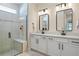 Bathroom with double sinks, granite countertops, sleek fixtures and walk in shower with bench at 9800 Bright Water Dr, Englewood, FL 34223