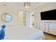 Bedroom features a king bed, wood floors, with a view to the ensuite, and a TV at 9800 Bright Water Dr, Englewood, FL 34223