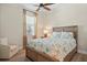 Bedroom features a queen bed, wood floors, designer ceiling fan and neutral decor at 9800 Bright Water Dr, Englewood, FL 34223