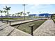 Bocce ball court with shade, offering a recreational space amidst tropical landscaping and a pool at 9800 Bright Water Dr, Englewood, FL 34223