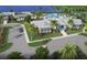 Aerial view of the community clubhouse, featuring a beautiful building, palm trees, and lush landscaping at 9800 Bright Water Dr, Englewood, FL 34223