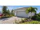 Attached two-car garage, complemented by a brick driveway and meticulously maintained landscaping at 9800 Bright Water Dr, Englewood, FL 34223