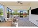 Screened in lanai with nice cushioned seating and beautiful outdoor view at 9800 Bright Water Dr, Englewood, FL 34223