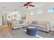 Bright living room features neutral decor, two sofas, wood floors, fan and easy access to other living areas at 9800 Bright Water Dr, Englewood, FL 34223