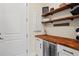 Pantry features custom shelving, wood countertop, wine fridge and a modern design at 9800 Bright Water Dr, Englewood, FL 34223