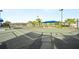Well-maintained tennis court with a shaded rest area and lush landscaping, perfect for active residents at 9800 Bright Water Dr, Englewood, FL 34223