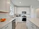 Bright kitchen features white cabinets, stainless steel appliances, granite countertops, and tile floors at 10399 Abaco Falls Dr, Englewood, FL 34223