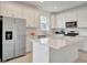 Stylish kitchen featuring white cabinets, stainless steel appliances, quartz counters and center island at 10399 Abaco Falls Dr, Englewood, FL 34223